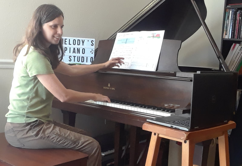 Teacher sitting at piano, explaining the lesson